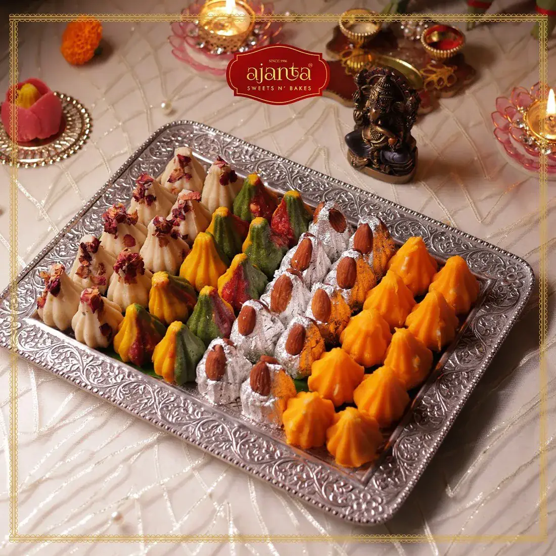Ajanta colourful modaks on silver tray with logo